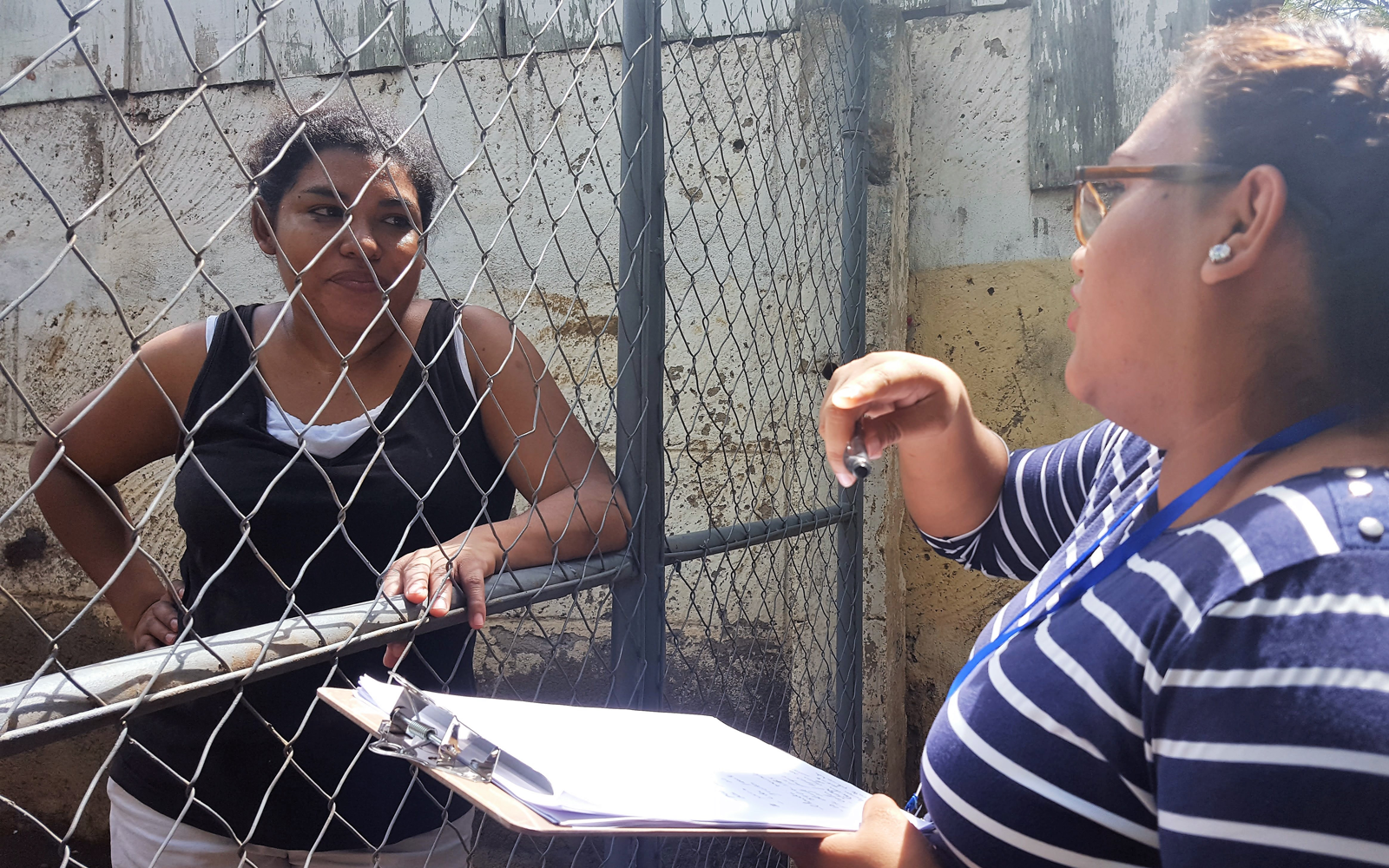 A youth organizer collects signatures for a petition asking the mayor to install streetlights in the neighborhood