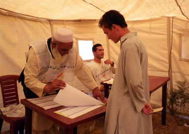 Polling station workers in Kabul prepare ballots for counting during the Aug. 20 elections.