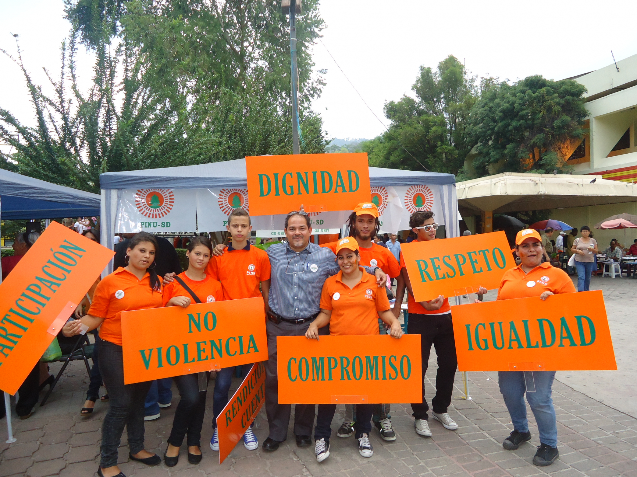 A group of Honduran activists hold orange signs in Spanish calling for an end to violence against women in politics.