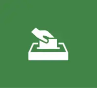 Hand inserting a ballot into a box