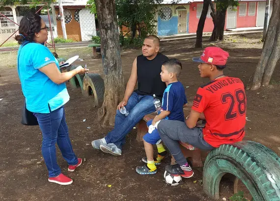 A youth organizer surveys members of the community about the most pressing issues affecting their neighborhood.