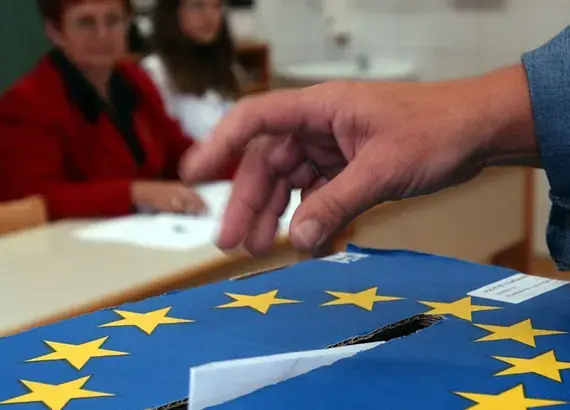 A Slovenian casts his ballot in a box bearing a European Union crest at a polling station in Grosuplje near Ljubljana, Sunday, Oct. 3, 2004. Credit: AP Photo/Darko Bandic