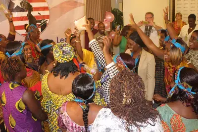 Liberian women participate in a role-playing workshop to practice encouraging rural women to register to vote. 