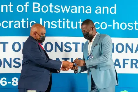 Former President Mokgweetsi Masisi of Botswana accepts the 'term limits baton' from civil society leaders in July 2022, signaling his commitment to respect presidential term limits in line with the constitution of Botswana