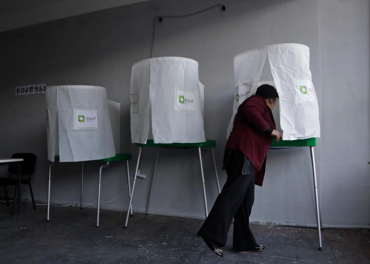 An election official prepares voting booths at a polling station ahead of Saturday's parliamentary elections in Tbilisi, Georgia, Friday, Oct. 7, 2016. (AP Photo/Sergei)